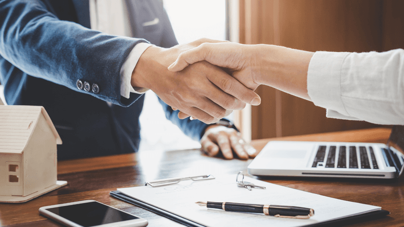 shaking hands over business desk