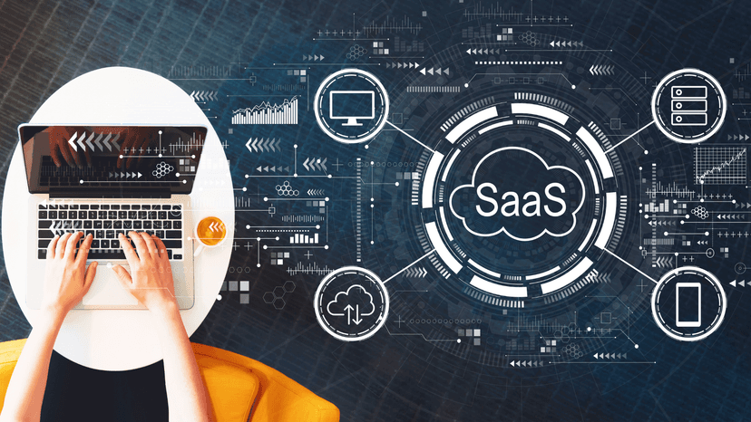 person working on laptop with SaaS related graphics