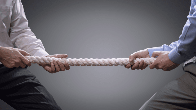 two sets of arms in business professional dress tugging on rope