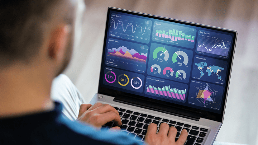 man working on laptop with finance digital dashboard