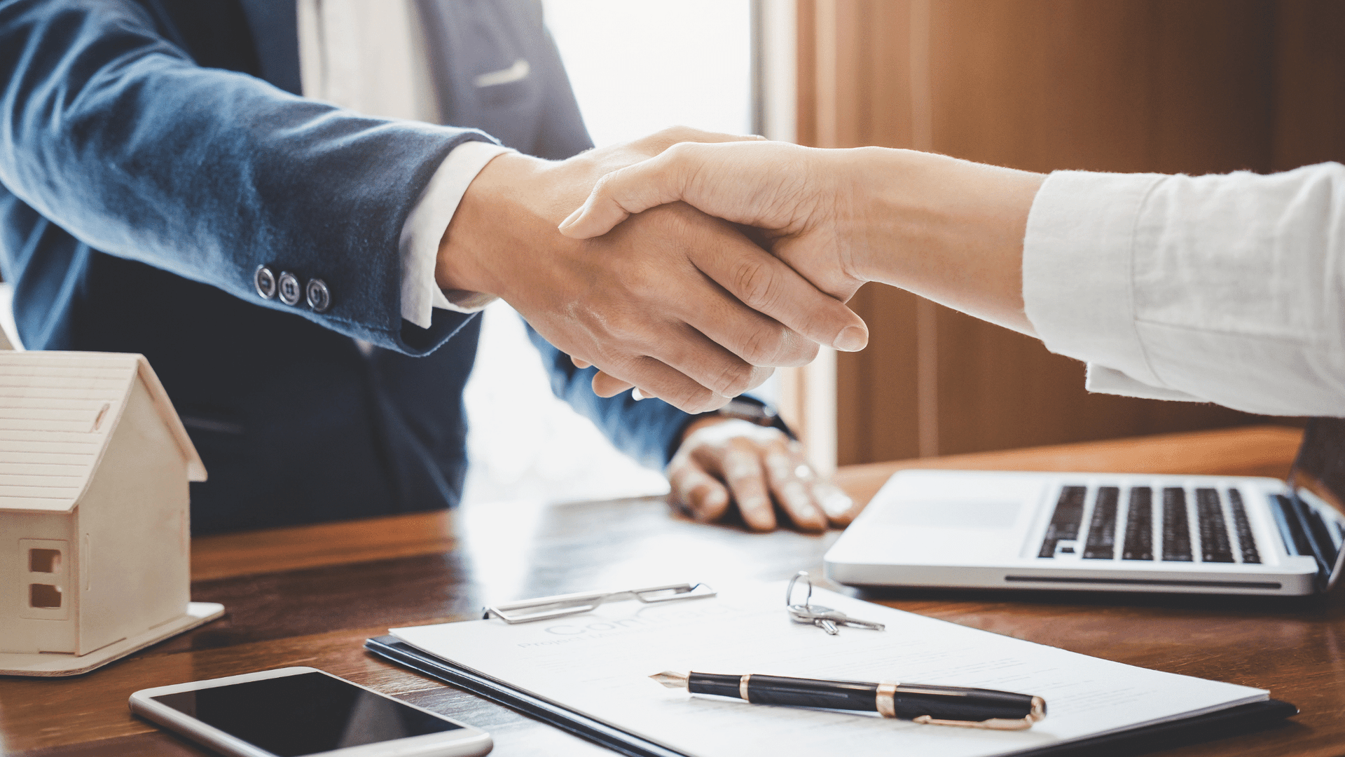 shaking hands over business desk